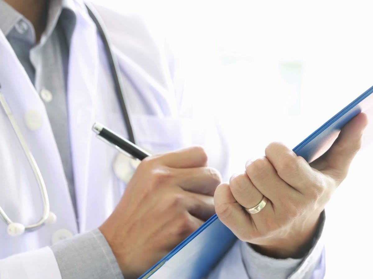 Personnel médical en blouse blanche avec un dossier de suivi